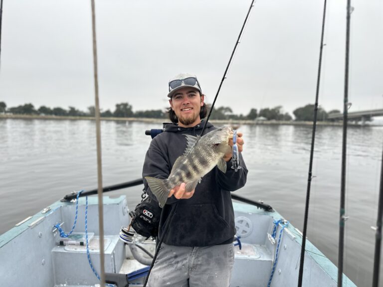man holding fish on boat
